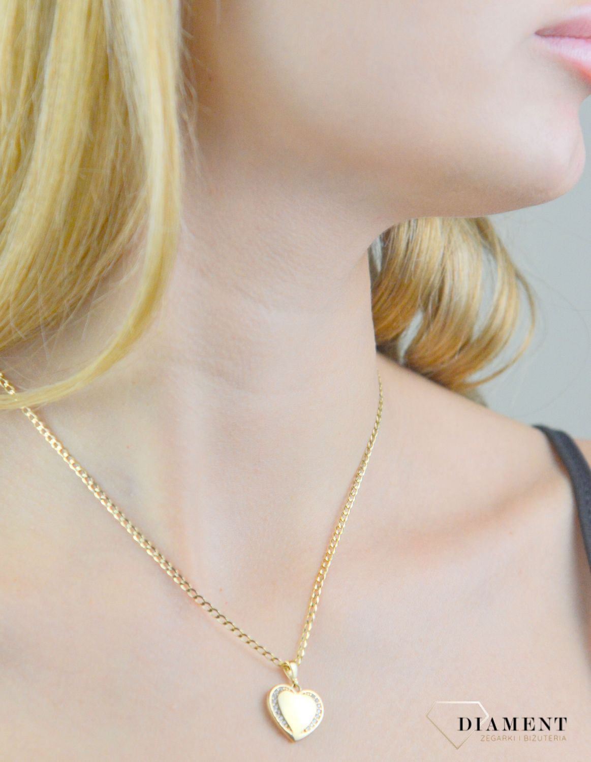 Piękna zawieszka w kształcie serca ozdobiona białą cyrkonią. Zawieszkę wykonano ze złota próby 585 o wadze 1,95 gram. Do zawieszki można dobrać delikatny złoty łańcuszek, który można znaleźć w naszej ofercie.  (2).jpg